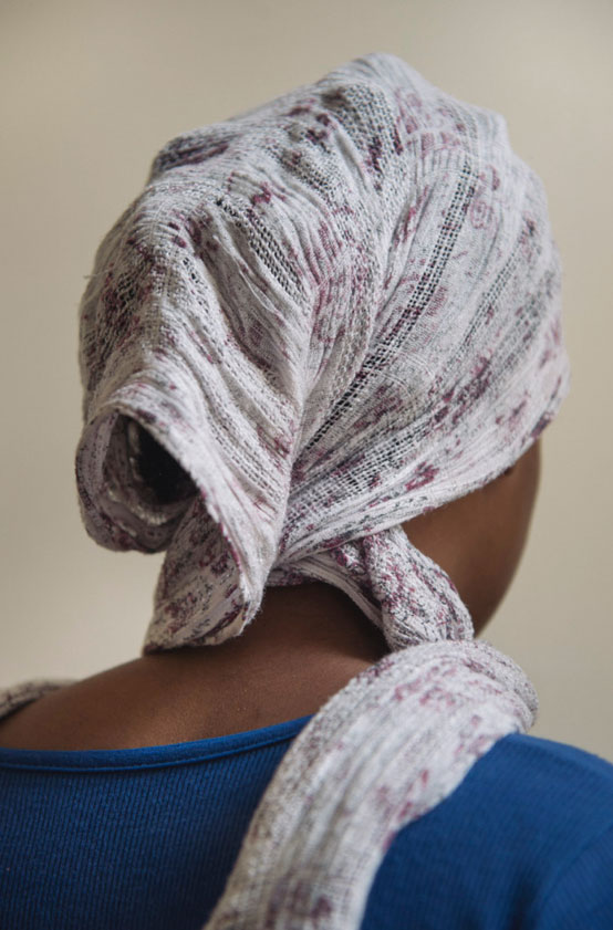 Mujer inmigrante de espaldas con pañuelo en la cabeza